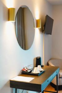 a room with a table with a mirror at The Village Hotel Douglas in Cork +19 photos