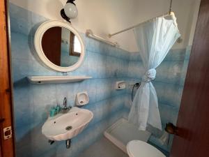 a bathroom with a sink and a mirror and a toilet at Poseidonio Apartments in Poseidónion