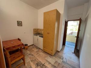 a kitchen with a wooden cabinet and a table at Poseidonio Apartments in Poseidónion +58 photos