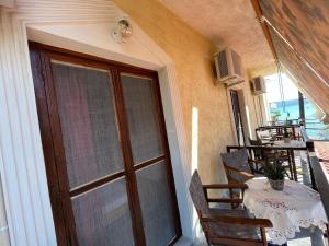 a balcony with a table and chairs and a window at Poseidonio Apartments in Poseidónion