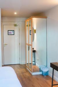 a bedroom with a closet and a bed and a desk at The Village Hotel Douglas in Cork