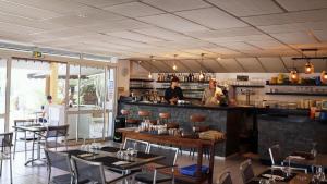 a restaurant with tables and a bar with people in it at Camping Tikayan Beau Séjour in Le Lavandou