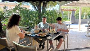 a group of people sitting at a table eating food at Camping Tikayan Beau Séjour in Le Lavandou +35 photos