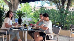 a group of people sitting at a table eating food at Camping Tikayan Beau Séjour in Le Lavandou