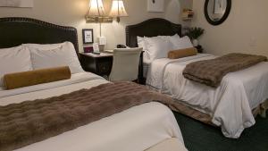 a hotel room with two beds and a desk at Amherst Inn - Virginia in Amherst