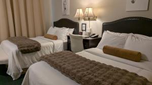 a hotel room with two beds and a desk at Amherst Inn - Virginia in Amherst