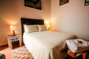 a bedroom with a large white bed and a table at Casa Amarilla in San Gil