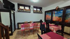 a dining room with tables and chairs and a flat screen tv at Pensiunea TV Condor in Sinaia
