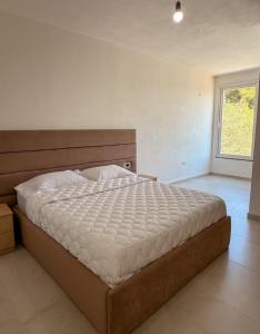 a bedroom with a large bed with a white comforter at Sea View Apartments in Durrës +17 photos