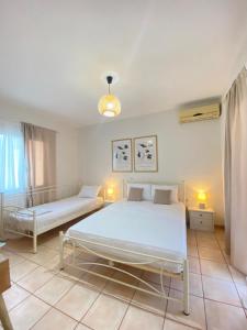 ein Schlafzimmer mit zwei Betten und zwei Lampen in der Unterkunft Lora Apartments & Studios with Balcony in Ipsos Corfu in Ýpsos