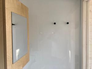 a mirror on the wall of a white wall at BONIS - Nidi nel Bosco in Montemaggiore
