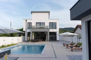 a large white house with a swimming pool at Villa H in Blagaj