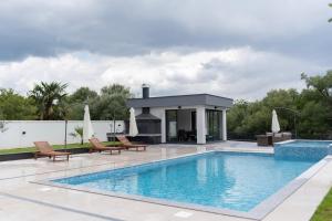 a swimming pool with a fireplace next to a house at Villa H in Blagaj