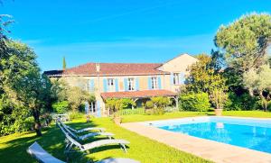 a house with a swimming pool and lounge chairs at Le Relais des Anges in Mercuès