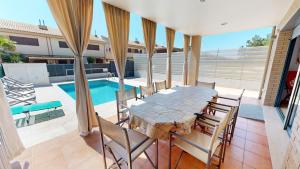 a patio with a table and chairs and a pool at Villa Arenal in L'Ampolla