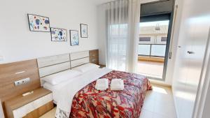 a bedroom with a bed with two towels on it at Villa Arenal in L'Ampolla +13 photos