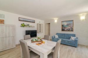 a living room with a table and a blue couch at Casa Flock in La Maddalena