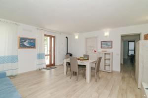 a living room with a table and chairs and a kitchen at Casa Flock in La Maddalena