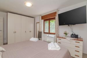 a bedroom with two beds and a flat screen tv at Casa Flock in La Maddalena
