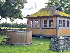 a small house with a tub in the yard at Sika Holiday Houses in Hellamaa +9 photos