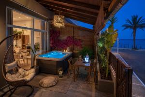 a balcony with a hot tub and a table at Ninemia Shore Retreat in Stalis in Stalís