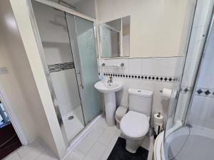 a bathroom with a toilet and a shower and a sink at Relax Stay 2 Bedroom in Theale