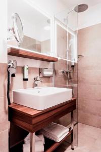 a bathroom with a white sink and a shower at DORMERO JeHo Graz Airport in Feldkirchen bei Graz