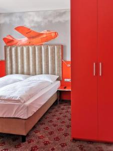 a bedroom with a bed with an airplane on the headboard at DORMERO JeHo Graz Airport in Feldkirchen bei Graz