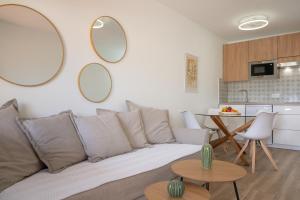 a living room with a couch and two mirrors on the wall at La casa de Samuel y Laia in Costa Calma