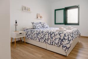 a bedroom with a bed with a blue and white comforter at La casa de Samuel y Laia in Costa Calma +40 photos