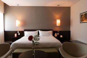 a bedroom with a bed and a vase with a flower on it at Hotel y Casino Del Río - General Roca in General Roca +39 photos