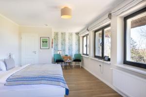 a bedroom with a bed and a table and chairs at Boutique-Hotel STRANDHAUS Ahrenshoop in Ahrenshoop