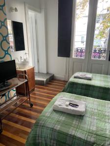 a room with two beds and a desk and a sink at Balcones de Cabrera in Buenos Aires