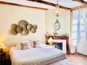 a bedroom with a bed and a clock on the wall at Le Relais des Anges in Mercuès +109 photos