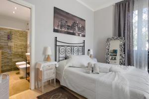 a bedroom with a white bed and a mirror at Il Giardino di Magò in Massa +32 photos