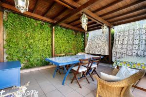 a patio with a table and chairs and a green wall at Il Giardino di Magò in Massa