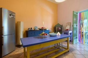 a kitchen with a blue table and a refrigerator at Il Giardino di Magò in Massa
