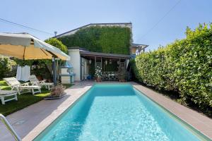 a swimming pool in the backyard of a house at Il Giardino di Magò in Massa