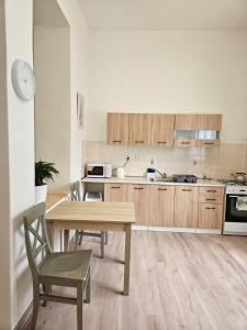 a kitchen with a wooden table and a table and chairs at Apartmán Příkrá in Děčín
