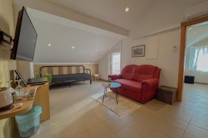a living room with a red couch and a television at Dorijini Dvori in Baška Voda