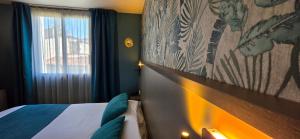 a hotel room with a bed and a window at Hôtel Le Valois, Cognac Centre in Cognac