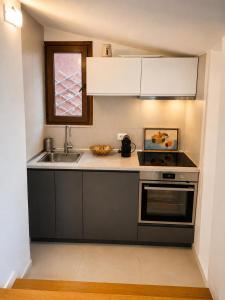 a small kitchen with a sink and a stove at Villasimius Il patio sul porto in Villasimius