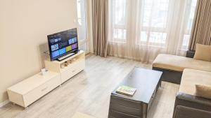 a living room with a television and a couch at Lux 2 Central Apartment with Garage in Plovdiv