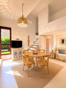 a living room with a table and chairs and a couch at Villasimius Il patio sul porto in Villasimius