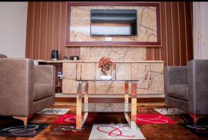 a room with a table and a television on a wall at Hillpark Hotel in Eldoret