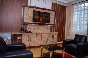 a living room with two chairs and a large stone wall at Hillpark Hotel in Eldoret +11 photos