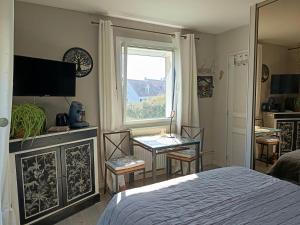 a bedroom with a bed and a window and a table at La Coccinelle Des Caps in Ambleteuse