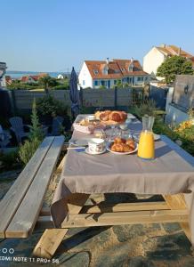 a picnic table with food and bread on it at La Coccinelle Des Caps in Ambleteuse