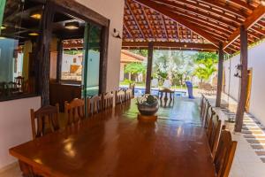 a dining room with a long table and chairs at Solarium Da Represa in Santa Branca