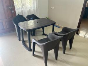 a table and chairs in a room with a table and chairs at RoyalNest Gardenia in Belgaum